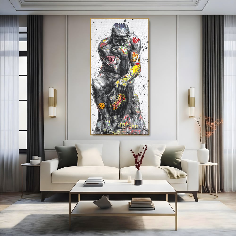 Tablou canvas cu tablou canvas cu statuia ganditorul, in rama de aluminiu auriu, pe perete intr-un living